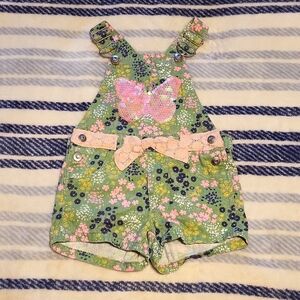 Green floral short bibs with sequin butterfly and pink lace belt details.